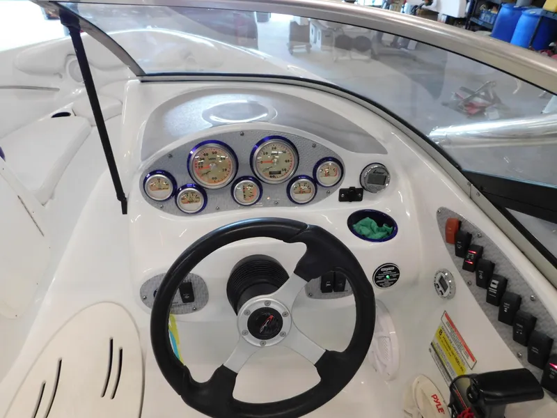Slide: The Image of Dashboard of a 2002 Baja 212 Islander boat with gauges and steering wheel. - 6