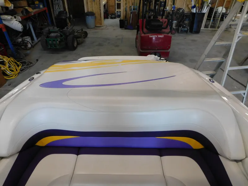 Slide: The Image of 2002 Baja 212 Islander boat with colorful upholstery in a workshop setting. - 7