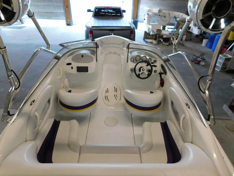 Slide: The Image of 2002 Baja 212 Islander boat interior with seating and steering wheel in a garage setting. - 9