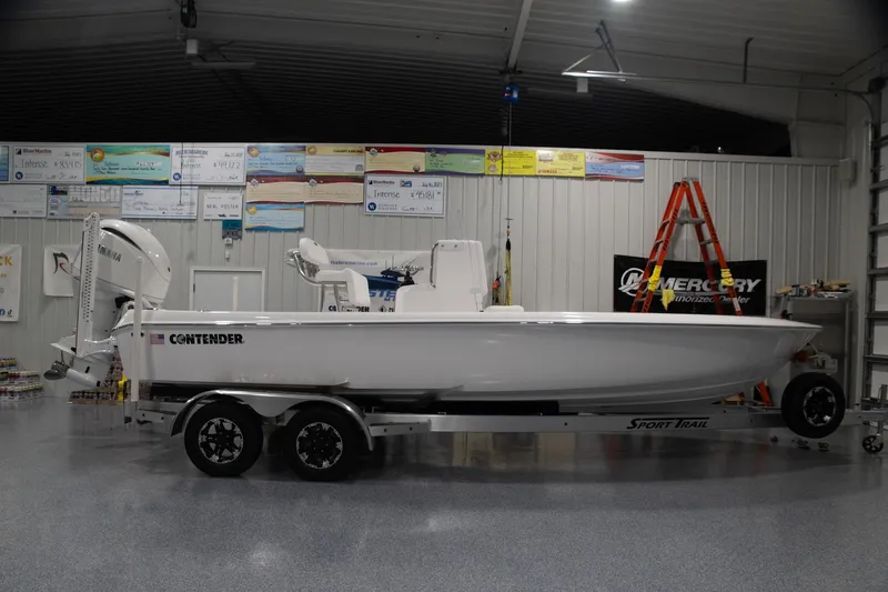 The Image of 2024 Contender 23 Bay boat on trailer in indoor showroom. - 0
