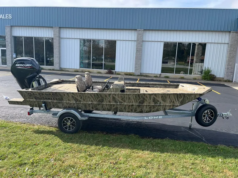 Slide: The Image of 2025 Lowe Roughneck 1760SC boat on trailer, parked outside a building. - 0