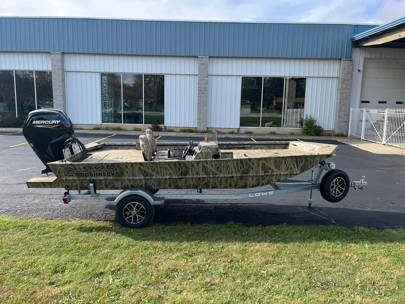 Slide: The Image of 2025 Lowe Roughneck 1760SC boat on trailer, parked outside a building. - 1