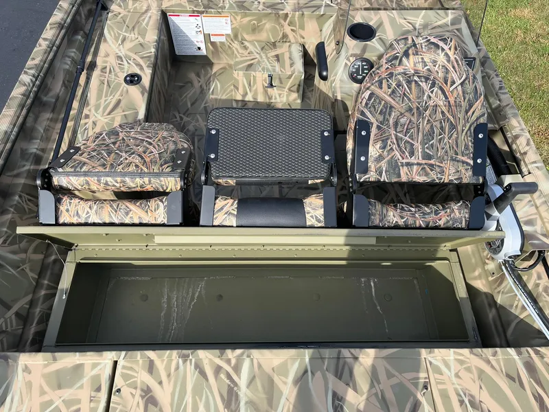 Slide: The Image of 2025 Lowe Roughneck 1760SC boat interior with camo seats and storage compartment. - 13