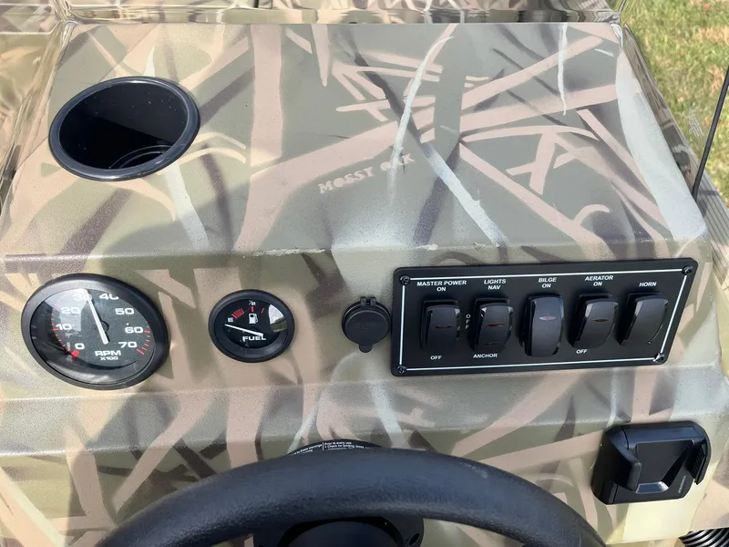 Slide: The Image of 2025 Lowe Roughneck 1760SC dashboard with camouflage design and control panel. - 16