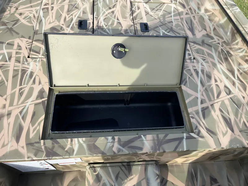 Slide: The Image of 2025 Lowe Roughneck 1760SC boat with open storage compartment, camo design. - 17