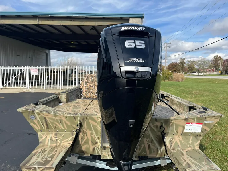 Slide: The Image of 2025 Lowe Roughneck 1760SC boat with Mercury 65 outboard motor, parked outdoors. - 3