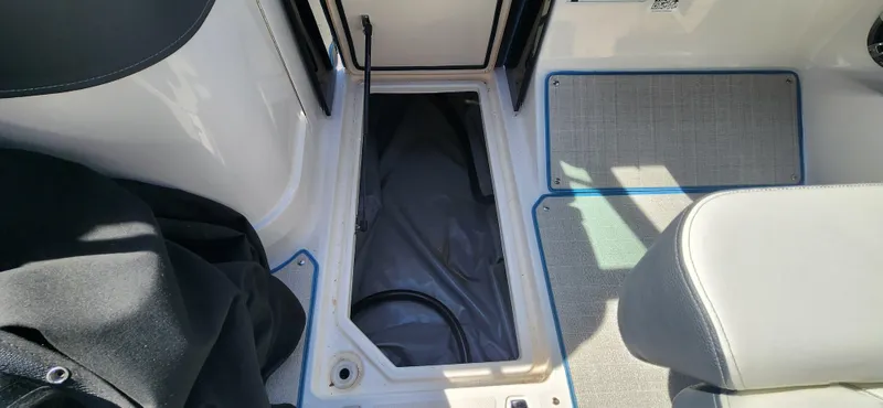 Slide: The Image of 2021 Regal LS6 Surf boat interior storage compartment with open hatch. - 13