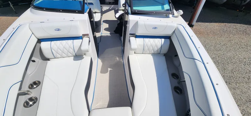 Slide: The Image of 2021 Regal LS6 Surf boat interior with white seating and blue accents. - 15