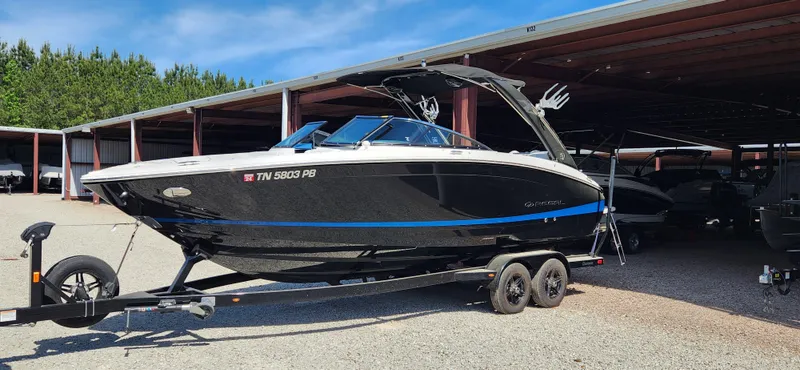Slide: The Image of 2021 Regal LS6 Surf boat on trailer in storage facility. - 2