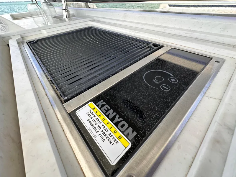 Slide: The Image of Kenyon grill on 2021 Tiara Sport 34 LS boat, featuring sleek design and safety warning. - 17