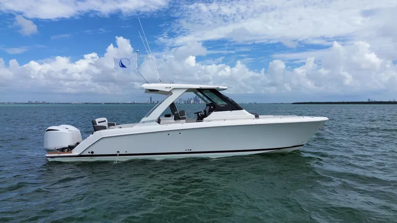 Slide: The Image of 2021 Tiara Sport 34 LS boat on open water under a partly cloudy sky. - 2