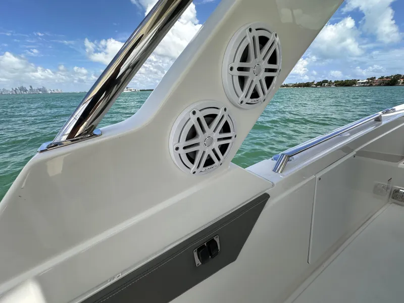 Slide: The Image of 2021 Tiara Sport 34 LS boat interior with speakers, ocean view, and clear sky. - 22