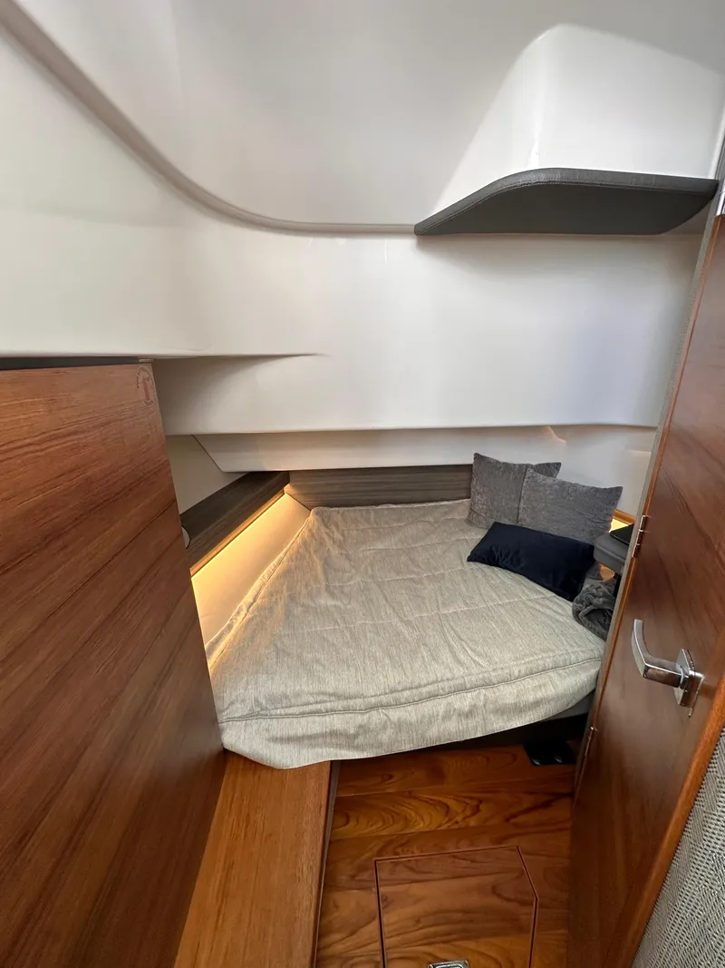 Slide: The Image of 2021 Tiara Sport 34 LS cabin interior with cozy bed and wooden accents. - 27