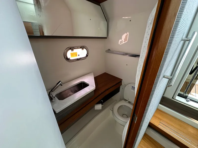Slide: The Image of 2021 Tiara Sport 34 LS boat bathroom with sink, toilet, and window. - 29
