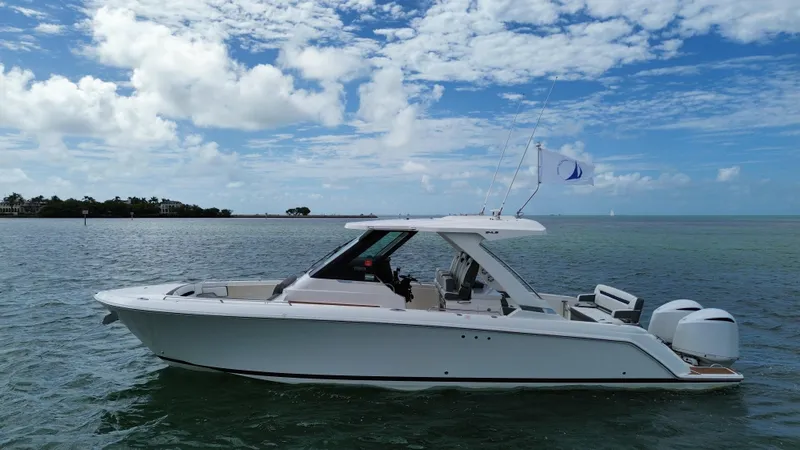 Slide: The Image of 2021 Tiara Sport 34 LS boat on calm water under a partly cloudy sky. - 3