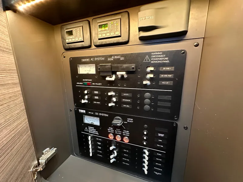 Slide: The Image of Control panel of a 2021 Tiara Sport 34 LS boat, featuring AC and DC systems. - 30