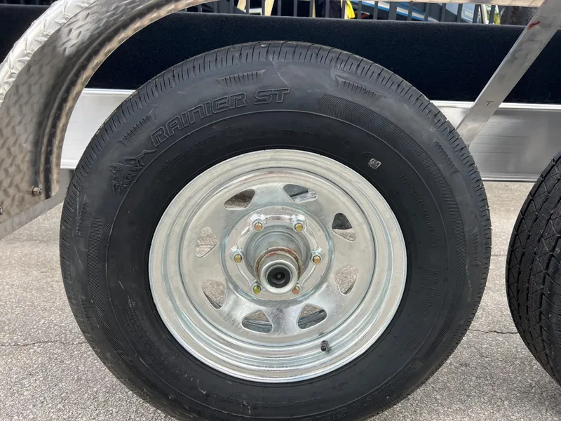 Slide: The Image of 2024 trailer wheel with Ranier ST tire on pavement. - 14