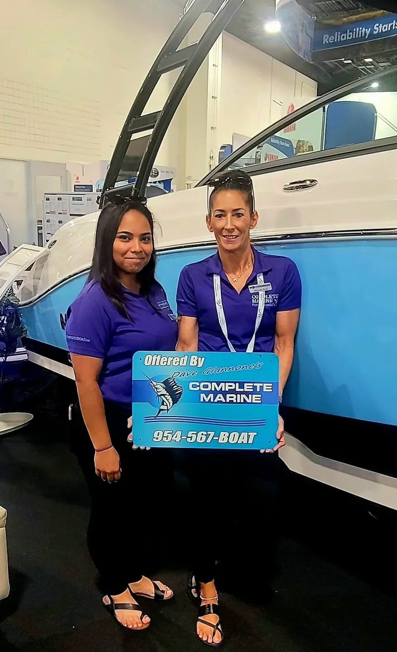 Slide: The Image of Two women in blue shirts holding a Complete Marine sign in front of a 2024 trailer. - 15