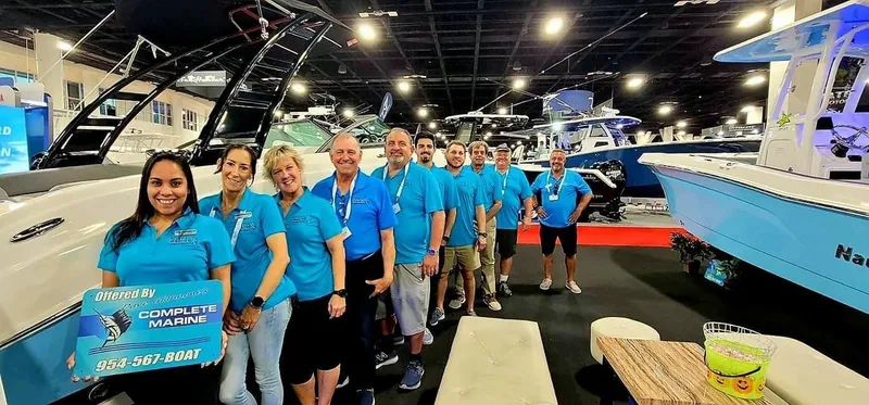 Slide: The Image of Group of people in blue shirts at a boat show, standing beside a 2024 trailer. - 17