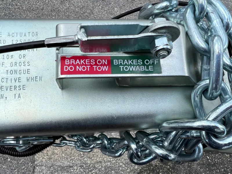 Slide: The Image of Trailer hitch with brake status indicators and safety chains, 2024 model. - 2