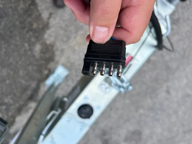 Slide: The Image of Close-up of a hand holding a 2024 trailer electrical connector plug. - 9