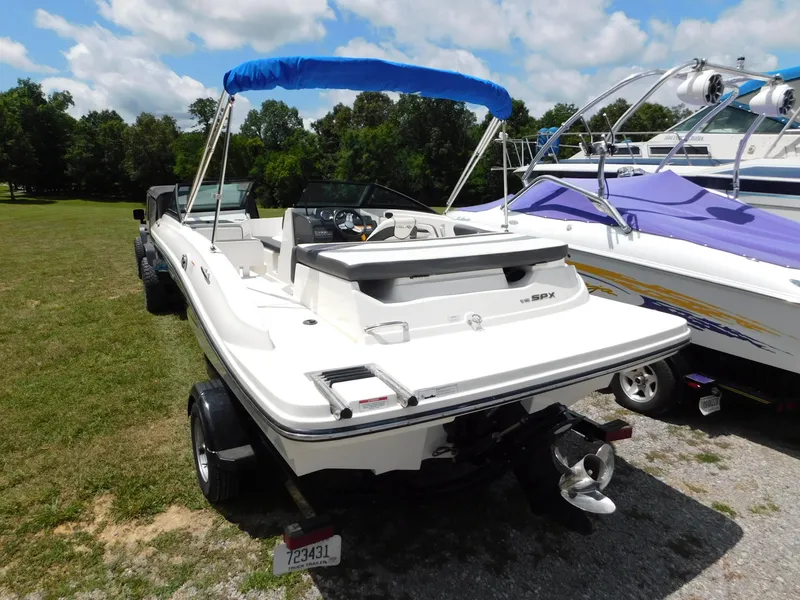 Slide: The Image of 2015 Sea Ray 19 SPX boat with blue canopy on trailer, parked outdoors. - 21