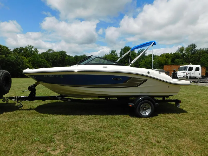 Slide: The Image of 2015 Sea Ray 19 SPX boat on trailer, parked on grassy field under cloudy sky. - 22