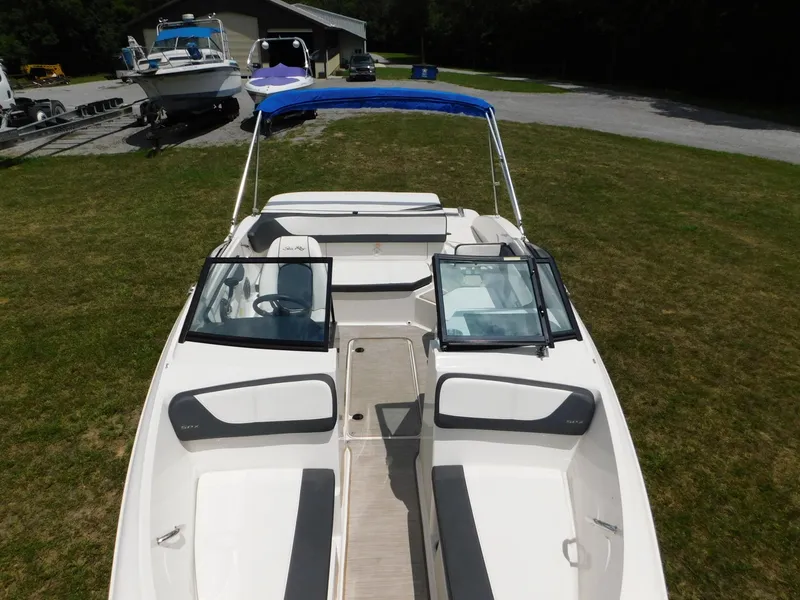 Slide: The Image of 2015 Sea Ray 19 SPX boat with blue canopy, parked on grass. - 26