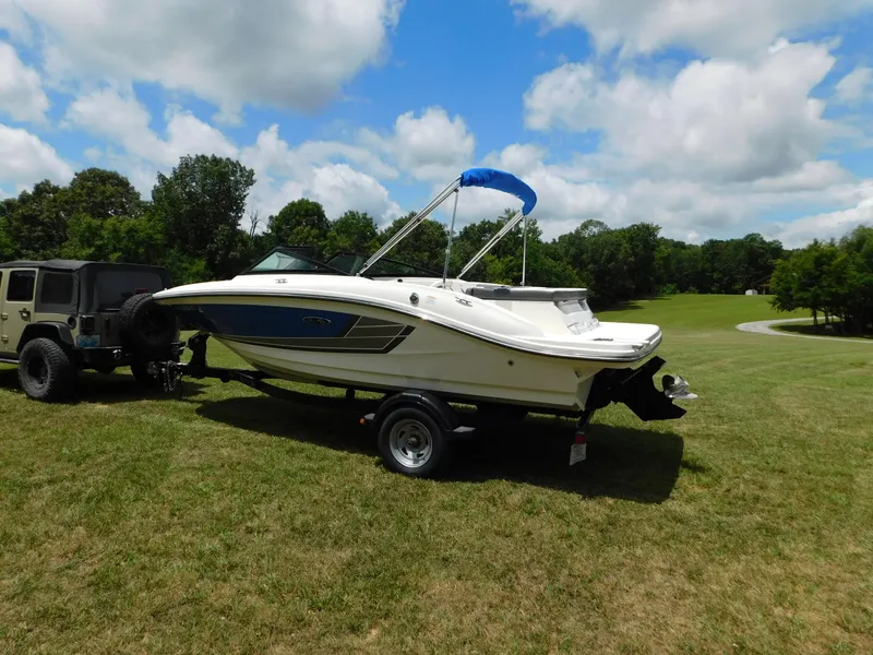 Slide: The Image of 2015 Sea Ray 19 SPX boat on trailer, parked on grassy field under blue sky. - 27