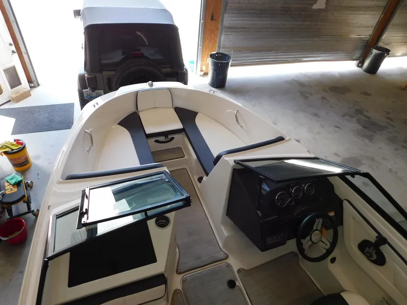 Slide: The Image of 2015 Sea Ray 19 SPX boat interior in garage, showing dashboard and seating. - 6