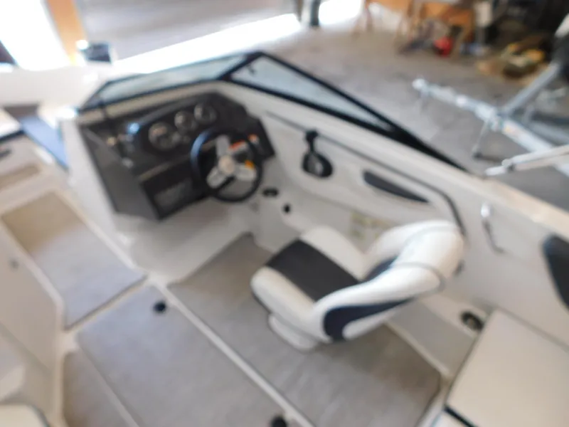 Slide: The Image of 2015 Sea Ray 19 SPX boat interior with steering wheel and seating. - 7