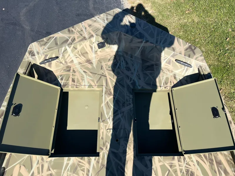 Slide: The Image of 2025 Lowe Roughneck 1760SC boat with open storage compartments and camouflage design. - 11