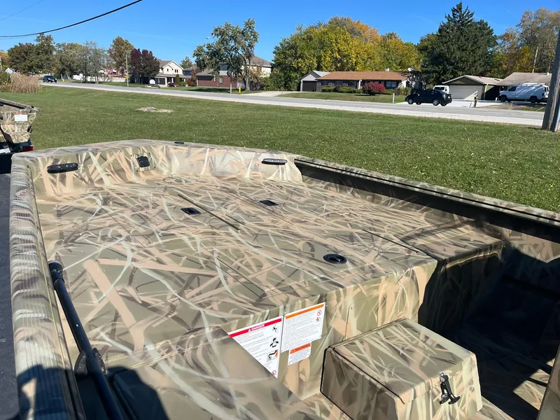 Slide: The Image of 2025 Lowe Roughneck 1760SC boat with camouflage design on grassy area. - 13