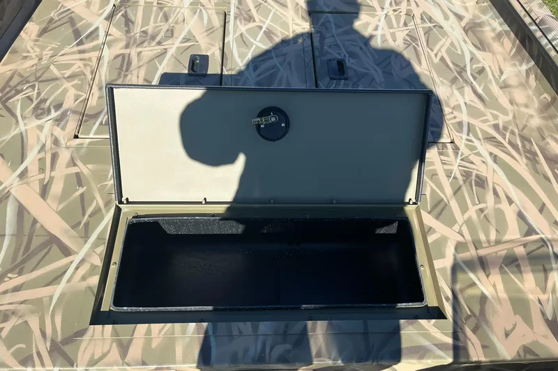 Slide: The Image of 2025 Lowe Roughneck 1760SC boat storage compartment with camouflage design. - 15