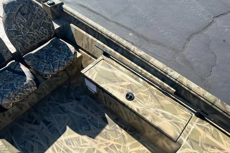 Slide: The Image of 2025 Lowe Roughneck 1760SC boat interior with camouflage seating and storage. - 16