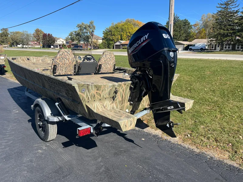 Slide: The Image of 2025 Lowe Roughneck 1760SC boat with Mercury engine on trailer, parked outdoors. - 3