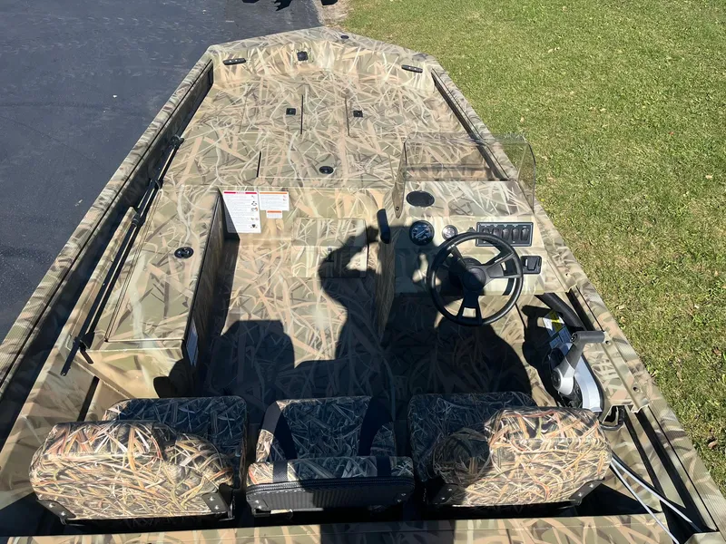 Slide: The Image of 2025 Lowe Roughneck 1760SC boat with camouflage design, steering wheel, and seating. - 5