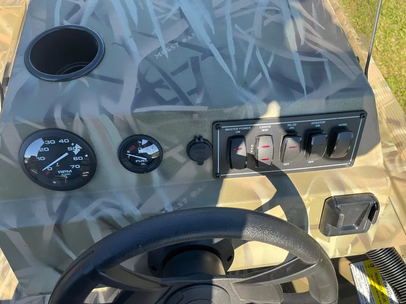 Slide: The Image of 2025 Lowe Roughneck 1760SC boat dashboard with gauges and controls. - 8