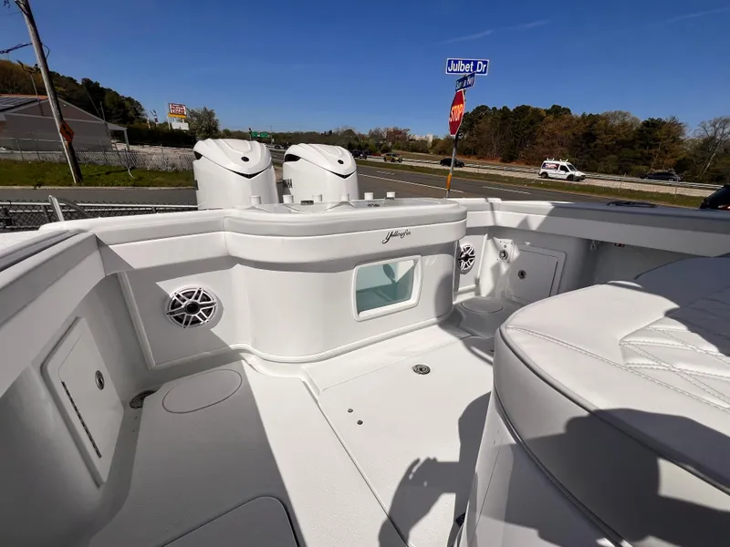 Slide: The Image of 2025 Yellowfin 32 boat interior with speakers and seating, parked near a road. - 1