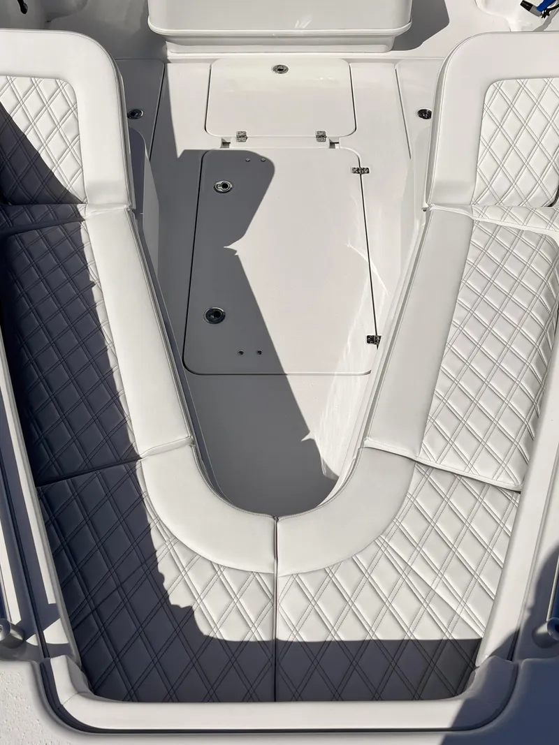 Slide: The Image of 2025 Yellowfin 32 boat interior with diamond-stitched seating and storage compartment. - 10