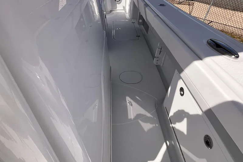 Slide: The Image of 2025 Yellowfin 32 boat interior, showcasing sleek white deck and storage compartments. - 16