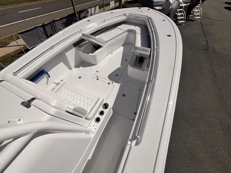 Slide: The Image of 2025 Yellowfin 32 boat with spacious deck and seating, parked on pavement. - 4