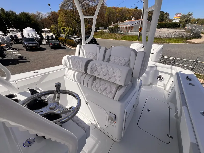 Slide: The Image of 2025 Yellowfin 32 boat interior with white cushioned seating and steering wheel. - 5