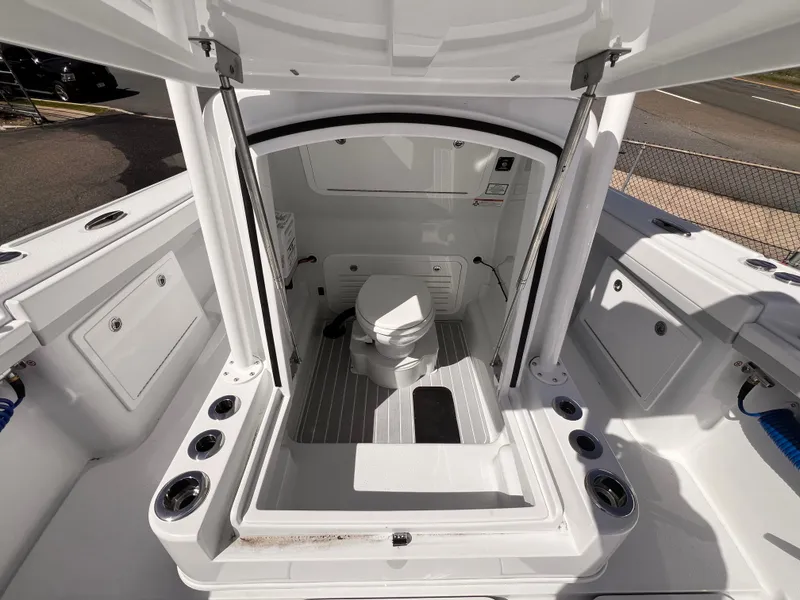 Slide: The Image of 2025 Yellowfin 32 boat interior with a compact marine toilet and storage compartments. - 6