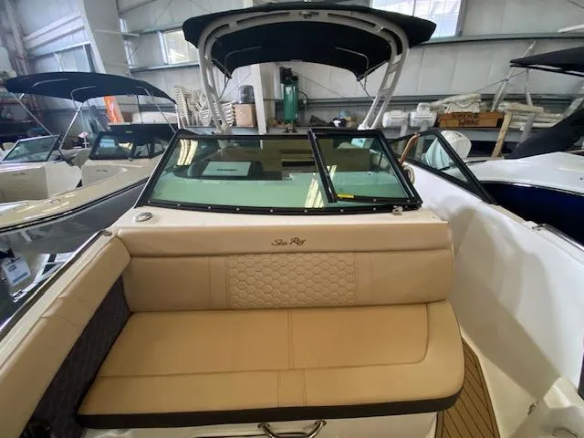 Slide: The Image of 2024 Sea Ray SDX 250 Outboard boat interior with beige seating in showroom. - 10