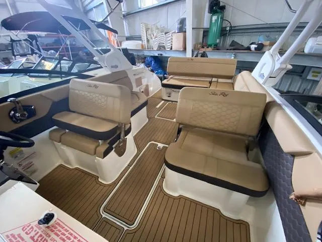 Slide: The Image of 2024 Sea Ray SDX 250 Outboard interior with tan seating and wood-style flooring. - 11