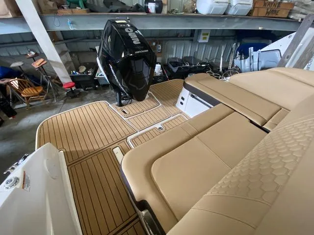 Slide: The Image of 2024 Sea Ray SDX 250 Outboard with tan seating and wood-style deck in storage. - 12