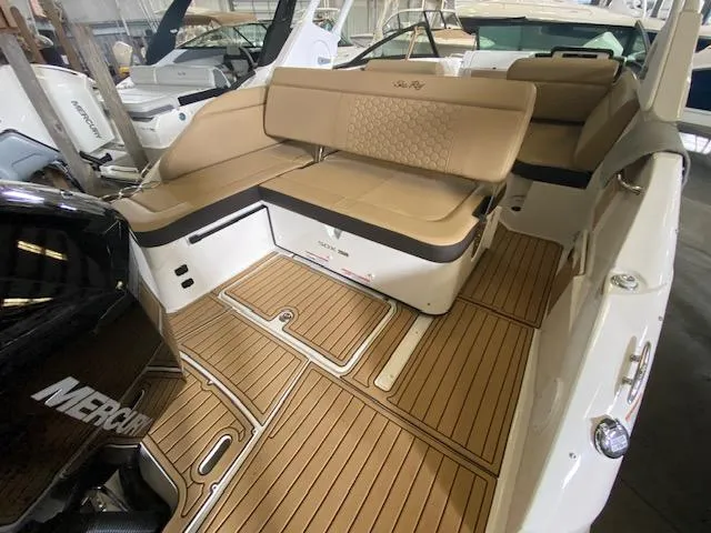 Slide: The Image of 2024 Sea Ray SDX 250 Outboard boat interior with tan seating and wood flooring. - 13