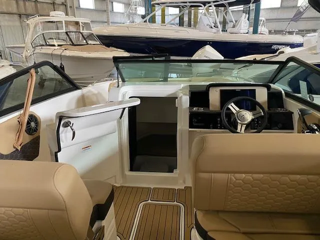 Slide: The Image of 2024 Sea Ray SDX 250 Outboard interior with beige seating and modern dashboard. - 16