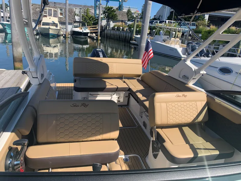 Slide: The Image of 2024 Sea Ray SDX 250 Outboard interior with tan seating at marina. - 19